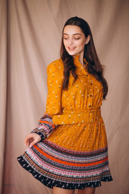 Young woman in a beautiful yellow dress in studio